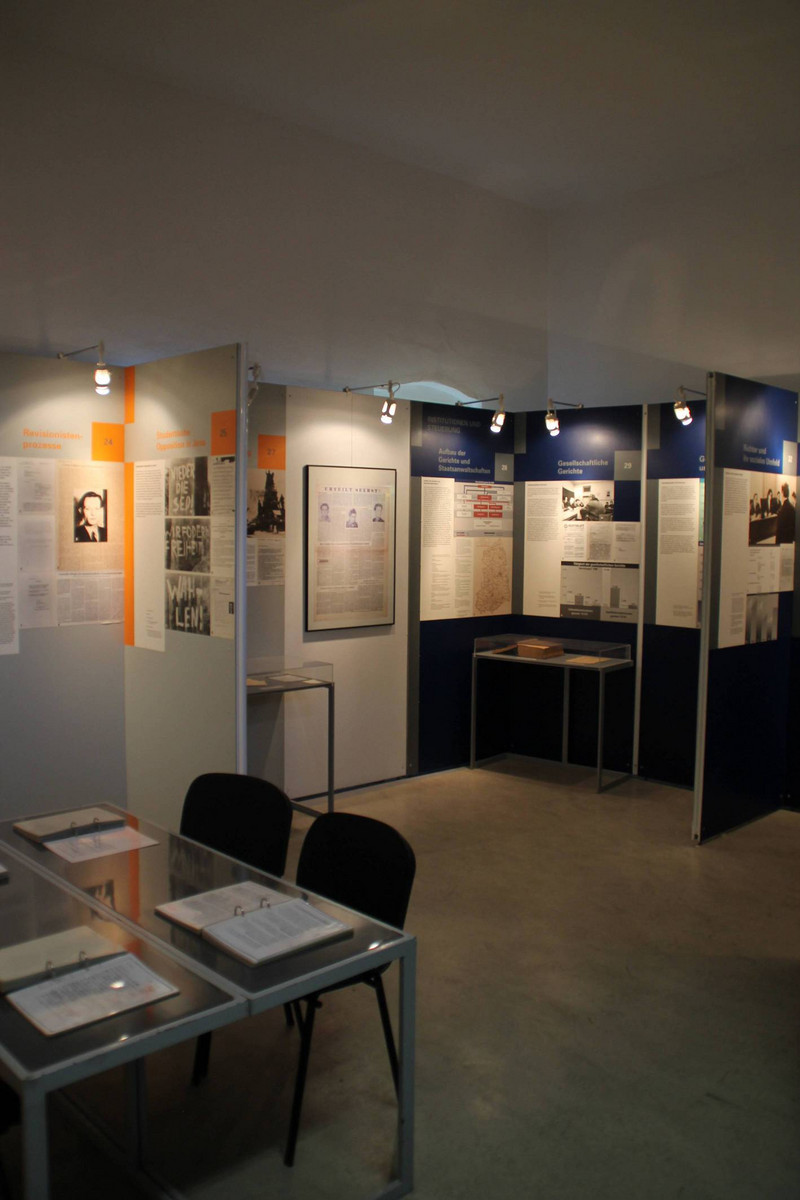Blick in die Ausstellung „Im Namen des Volkes? Über die Justiz im Staat der SED“, Aufnahme 2014. Im Vordergrund Vertiefungsebene mit Lesemappen.
